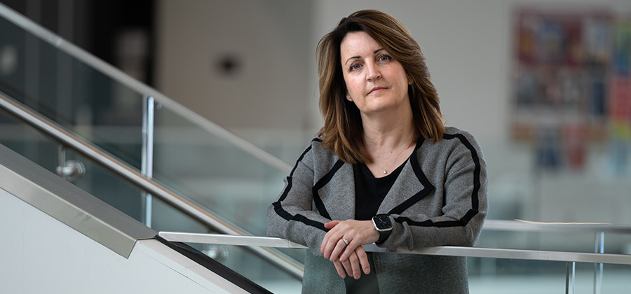 Christine Pope in Allard Hall wearing a grey and black blazer